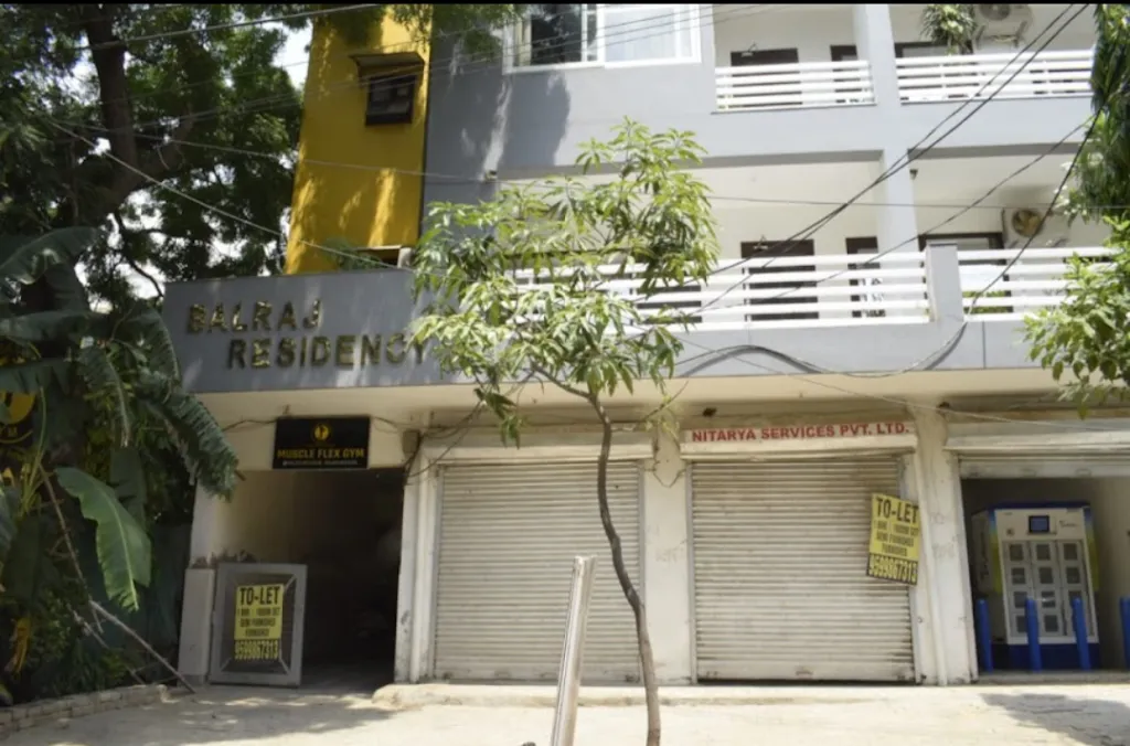 The Muscle Flex Gym signboard at its ground-floor entrance in Balraj Residency, Chanderlok, DLF Phase IV.